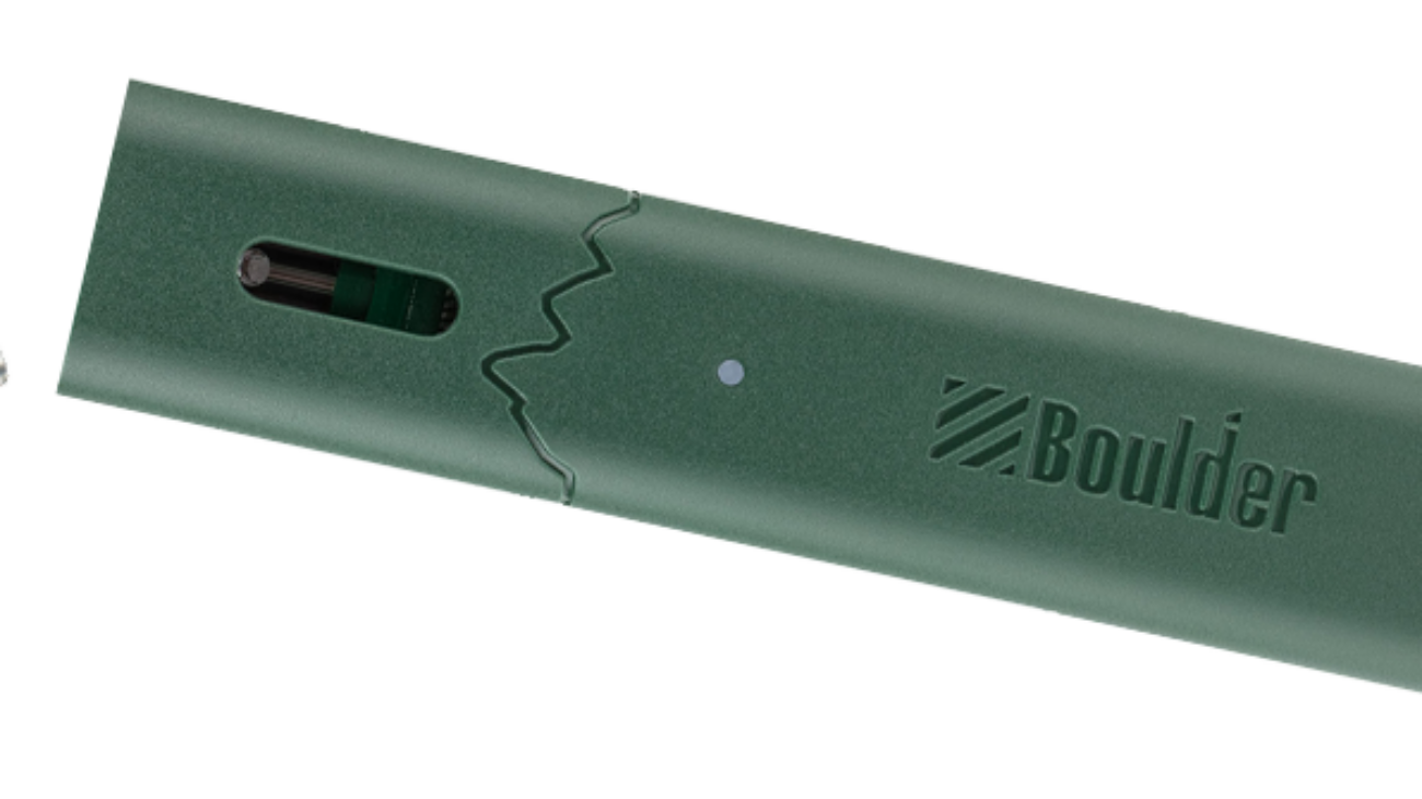Close-up of a green electronic device with a charging port and LED indicator.